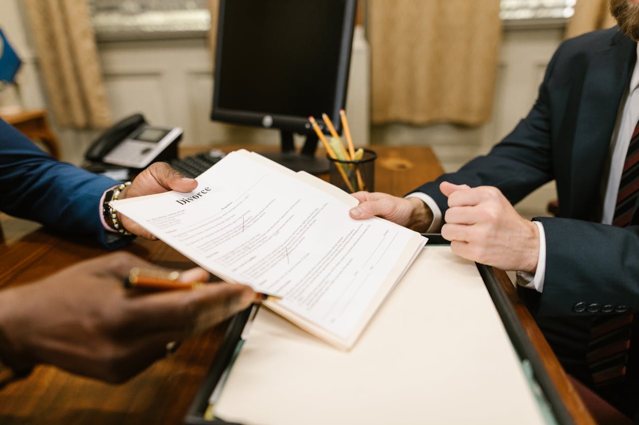 How to Know If Your Attorney Committed Malpractice in Commercial Litigation (and What to Do Next) 2 Close-up of hands exchanging divorce documents during legal proceedings in office.